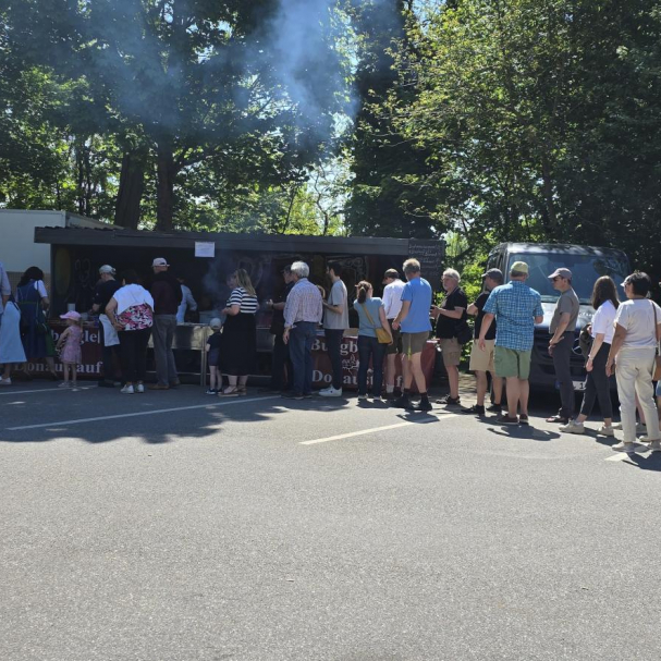 Besucher stehen am Bratwurststand