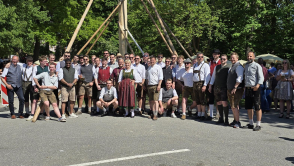 Gruppenfoto mit Maibaumaufsteller vor dem aufgestellten Maibaum
