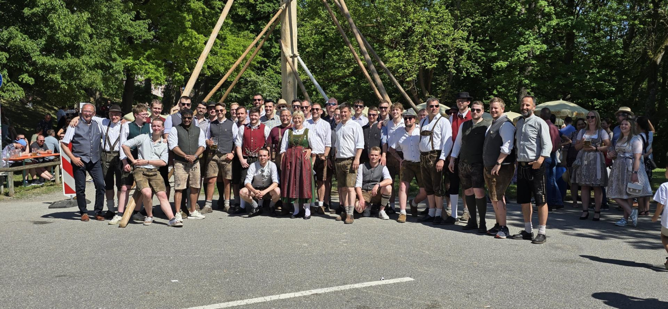 Gruppenfoto mit Maibaumaufsteller vor dem aufgestellten Maibaum